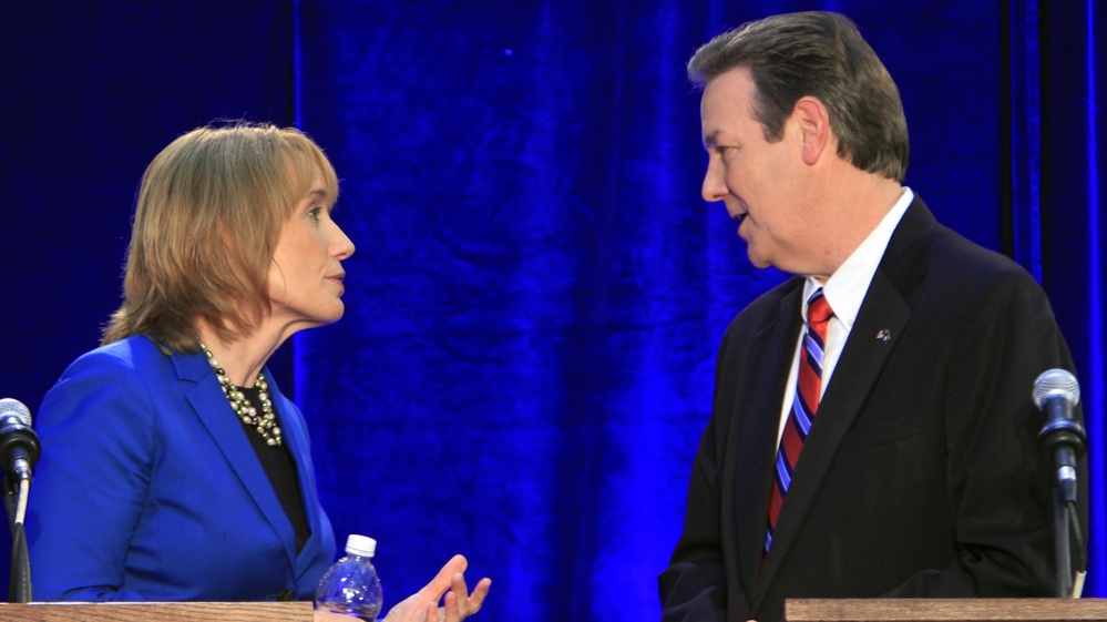Democrat Maggie Hassan and Republican Ovide Lamontagne talk during a break in their gubernatorial debate in Henniker, N.H., on Oct. 4.