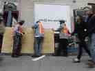 Workers cover an entrance with plywood at a subway station in New York City in preparation for flooding from Hurricane Sandy.