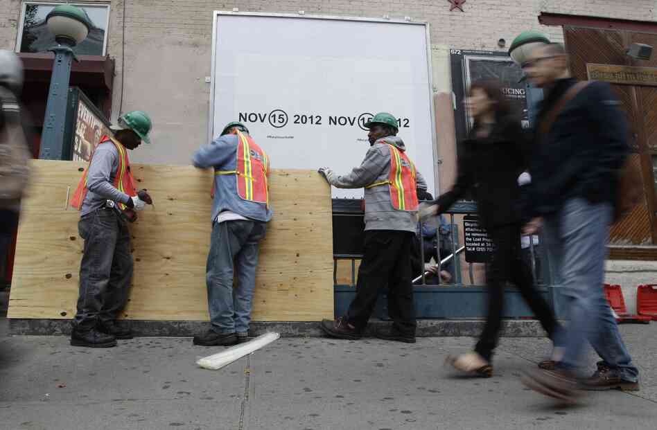 Workers cover an entrance with plywood at a subway station in New York City in preparation for flooding from Hurricane Sandy.