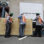 Workers cover an entrance with plywood at a subway station in New York City in preparation for flooding from Hurricane Sandy.