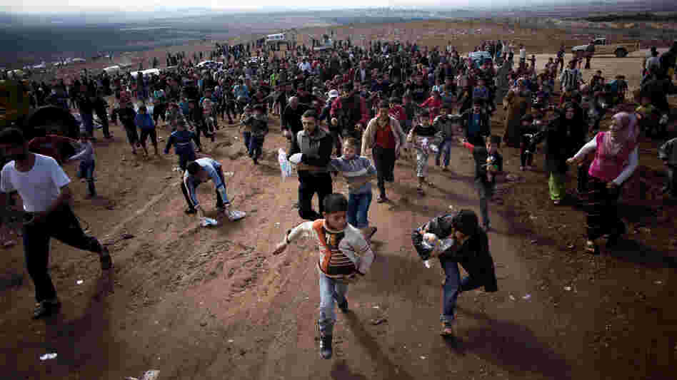 Children run after a truck loaded with presents for Eid Al-Adha in a refugee camp near Atma, Idlib province, Syria. A powerful car bomb exploded in Damascus on Friday and scattered fighting broke out in several areas across Syria, quickly dashing any hopes that a holiday cease-fire would hold.