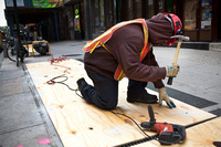 A construction worker covers air vents that could cause the New York subway system to flood in preparation for Hurricane Sandy on Sunday. The city is closing its transit system, as are Philadelphia and Washington, D.C.