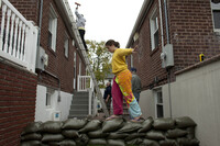 Bridget Donnelly walks on a sandbag wall outside her home in the Rockaway Beach neighborhood of Queens in New York City. Mayor Michael Bloomberg announced a mandatory evacuation of the city's low-lying coastal areas.