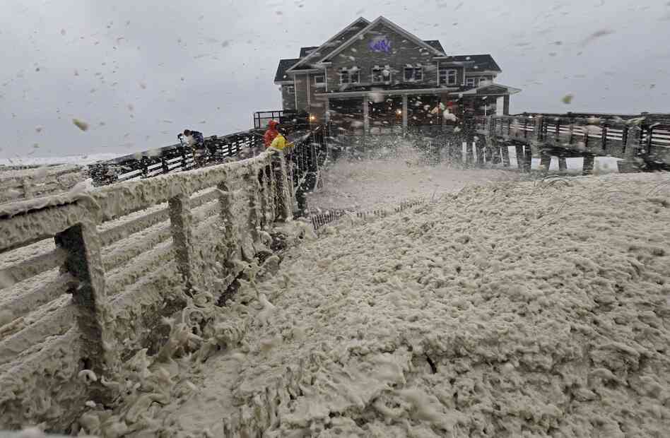High winds blow sea foam onto Jennette's Pier in Nags Head, N.C., on Sunday, as wind and rain from Hurricane Sandy move into the area.