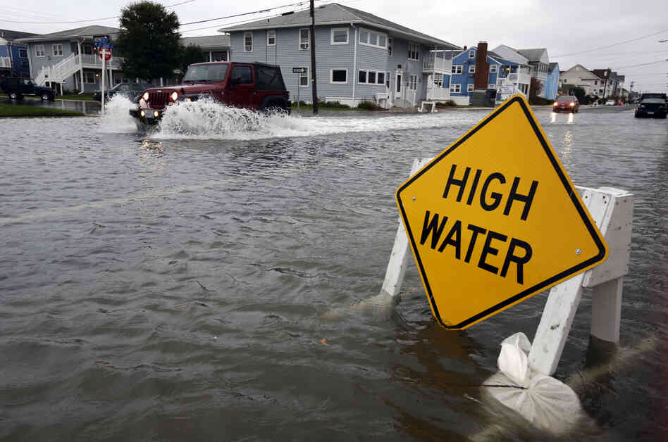 A car goes through the high water in Ocean City, Md. The state canceled early voting that had been scheduled for Monday.