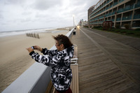Mary Corrus takes a picture of the rough surf as Hurricane Sandy bears down on Ocean City, Md.