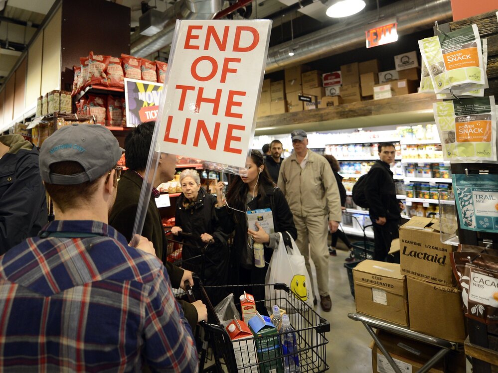 People try to get through the aisles at Whole Foods Market in Midtown in New York on Sunday before the storm.