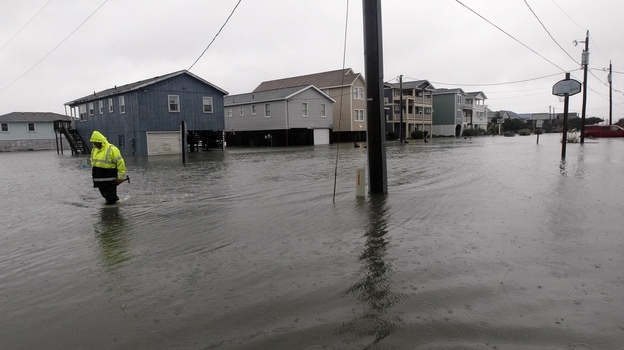 A Dare County utility worker checks on conditions along a flooded Ride Lane in Kitty Hawk, N.C., Monday, Oct. 29, 2012.