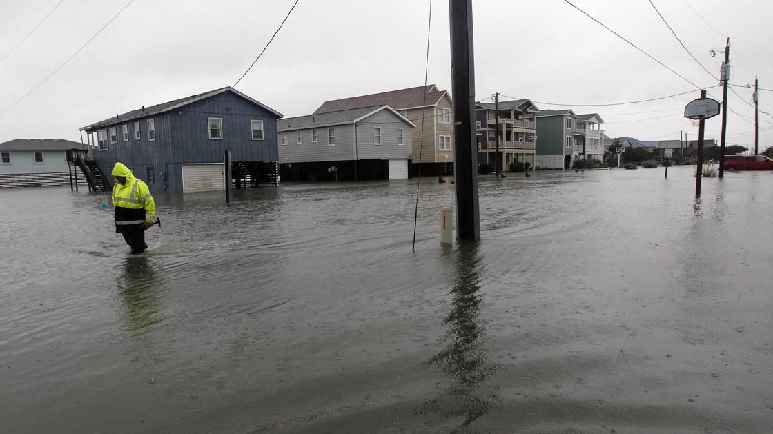 A Dare County utility worker checks on conditions along a flooded Ride Lane in Kitty Hawk, N.C., Monday, Oct. 29, 2012.