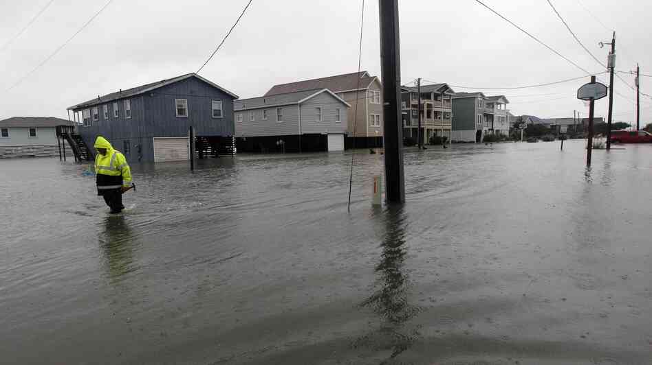A Dare County utility worker checks on conditions along a flooded Ride Lane in Kitty Hawk, N.C., Monday, Oct. 29, 2012.