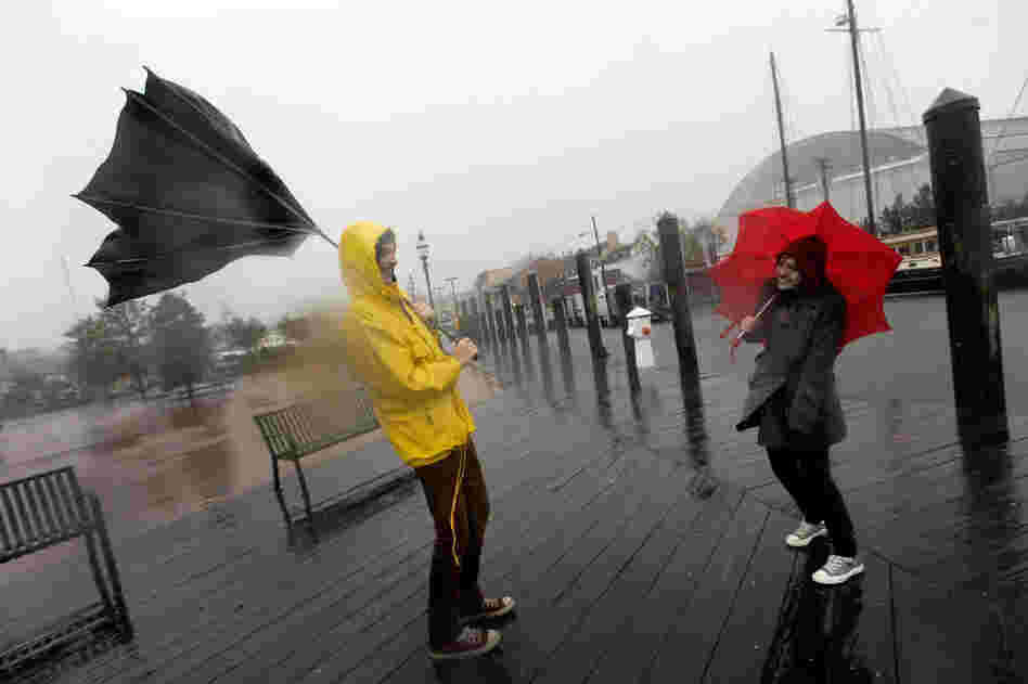 Jake Wilkerson (left) and Kaityln Baker struggle with their umbrellas as Hurricane Sandy approaches Annapolis, Md.