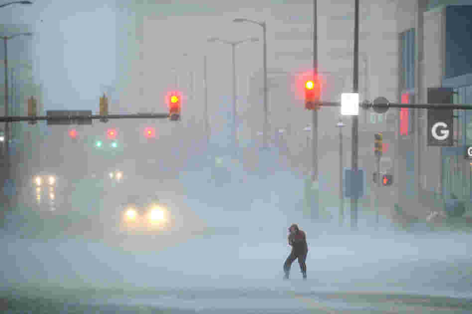 A journalist struggles to cross the street in Atlantic City. The city is like a ghost town, with casinos shuttered, tourists gone and many parts of the town inundated in knee-high water.