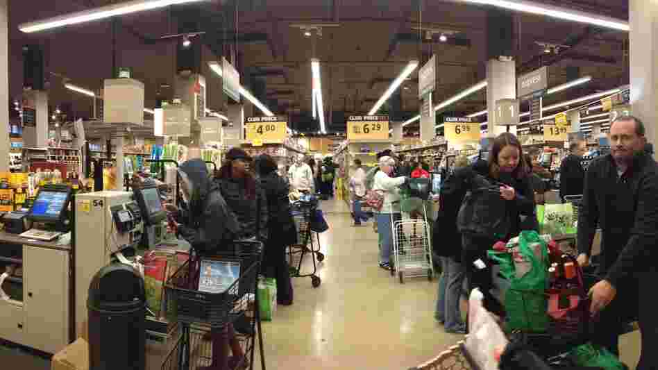 People wait to purchase groceries in self-checkout lanes at Safeway in Washington, D.C.