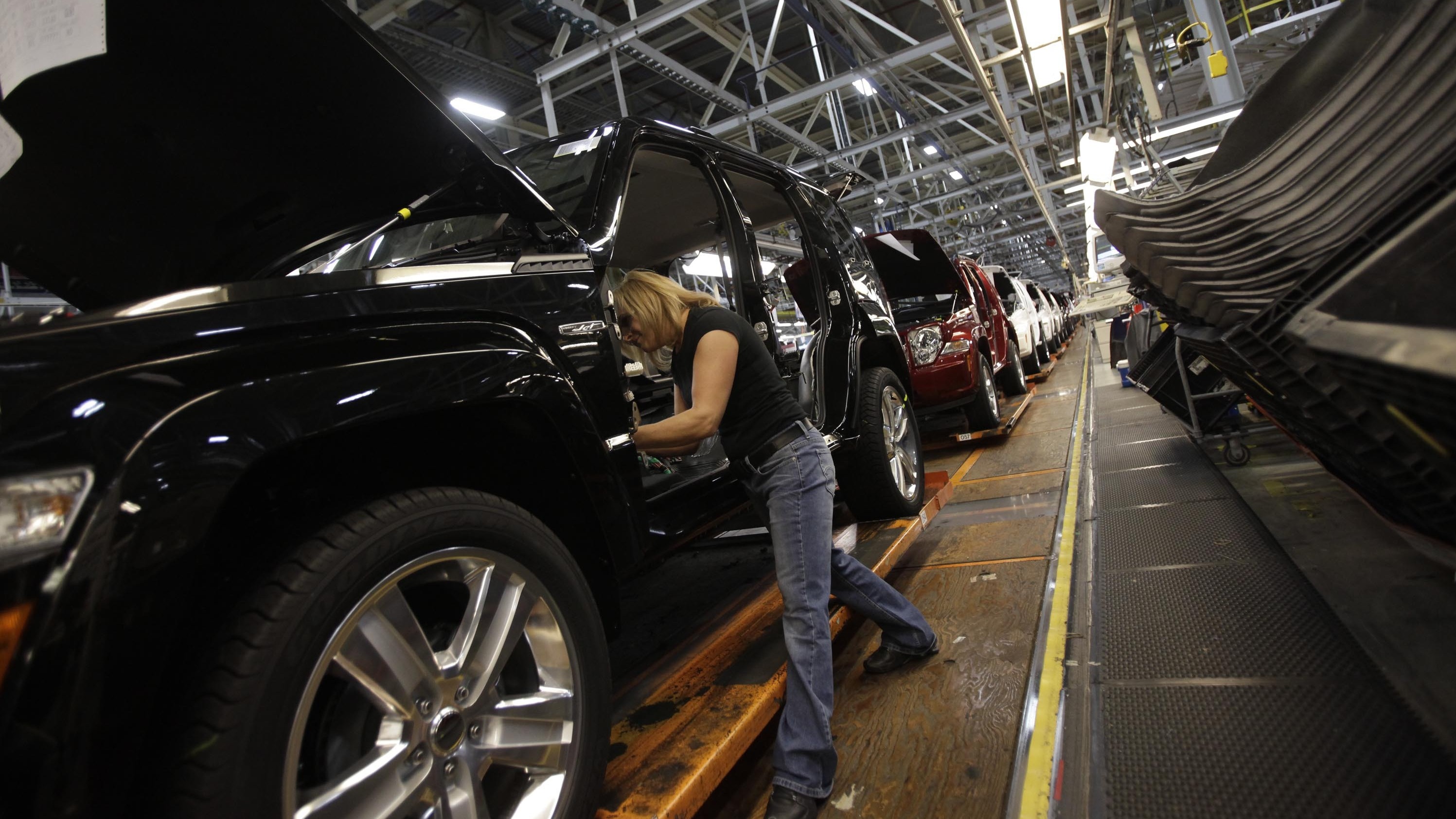 A worker installs carpet into a Jeep Liberty at the Toledo Assembly Complex in Toledo, Ohio, in 2011. (Image credit: Getty Images)
