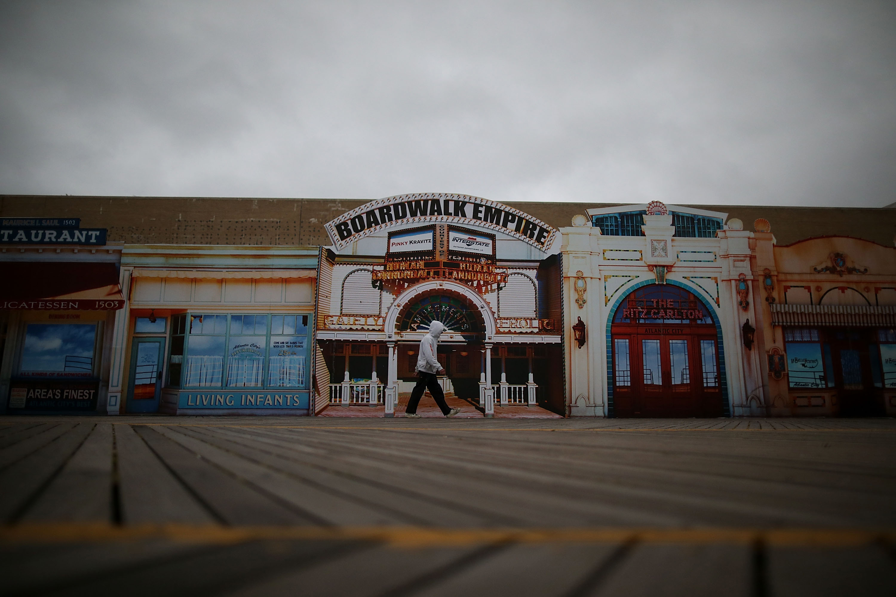 A man walks down a seemingly empty boardwalk as Hurricane Sandy approaches on Sunday in Atlantic City, N.J.