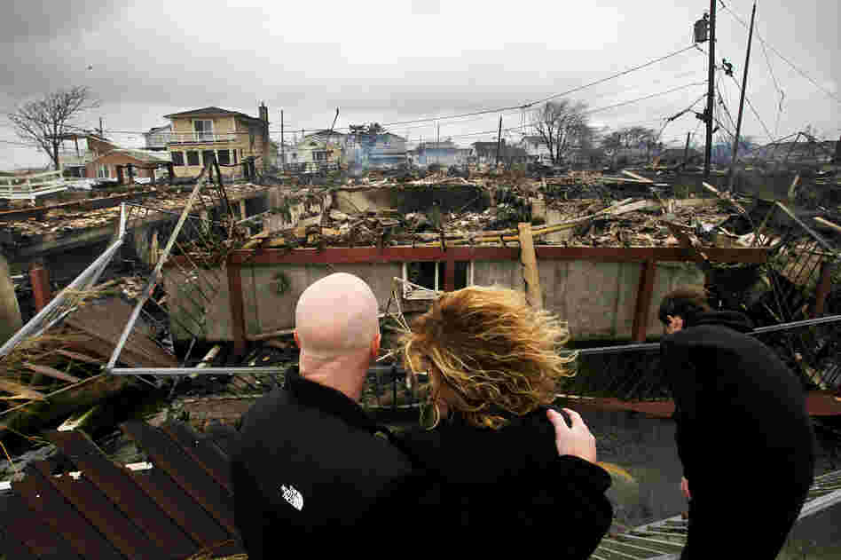 Robert Connolly, left, embraces his wife Laura as they survey the remains of her parent's home that burned to the ground in the Breezy Point section of Queens, N.Y. More than 50 homes were destroyed in the fire which swept through the oceanfront community during Superstorm Sandy. At right is their son, Kyle.