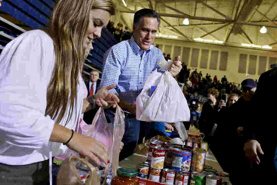 Republican presidential candidate Mitt Romney holds bags of food as he participates in a campaign event collecting supplies for victims of Sandy at the James S. Trent Arena in Kettering, Ohio.