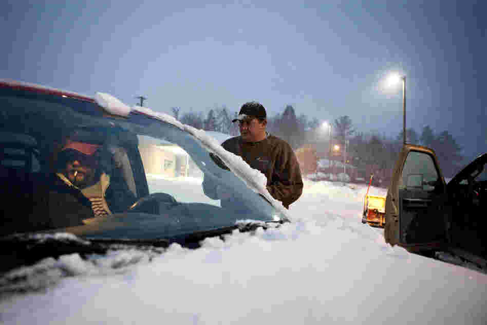 Matt Brewer, right, with Brickman Facility Solutions, a landscaping company, came from Ohio to help with snow removal in Beckley, W. Va., on Oct. 30.