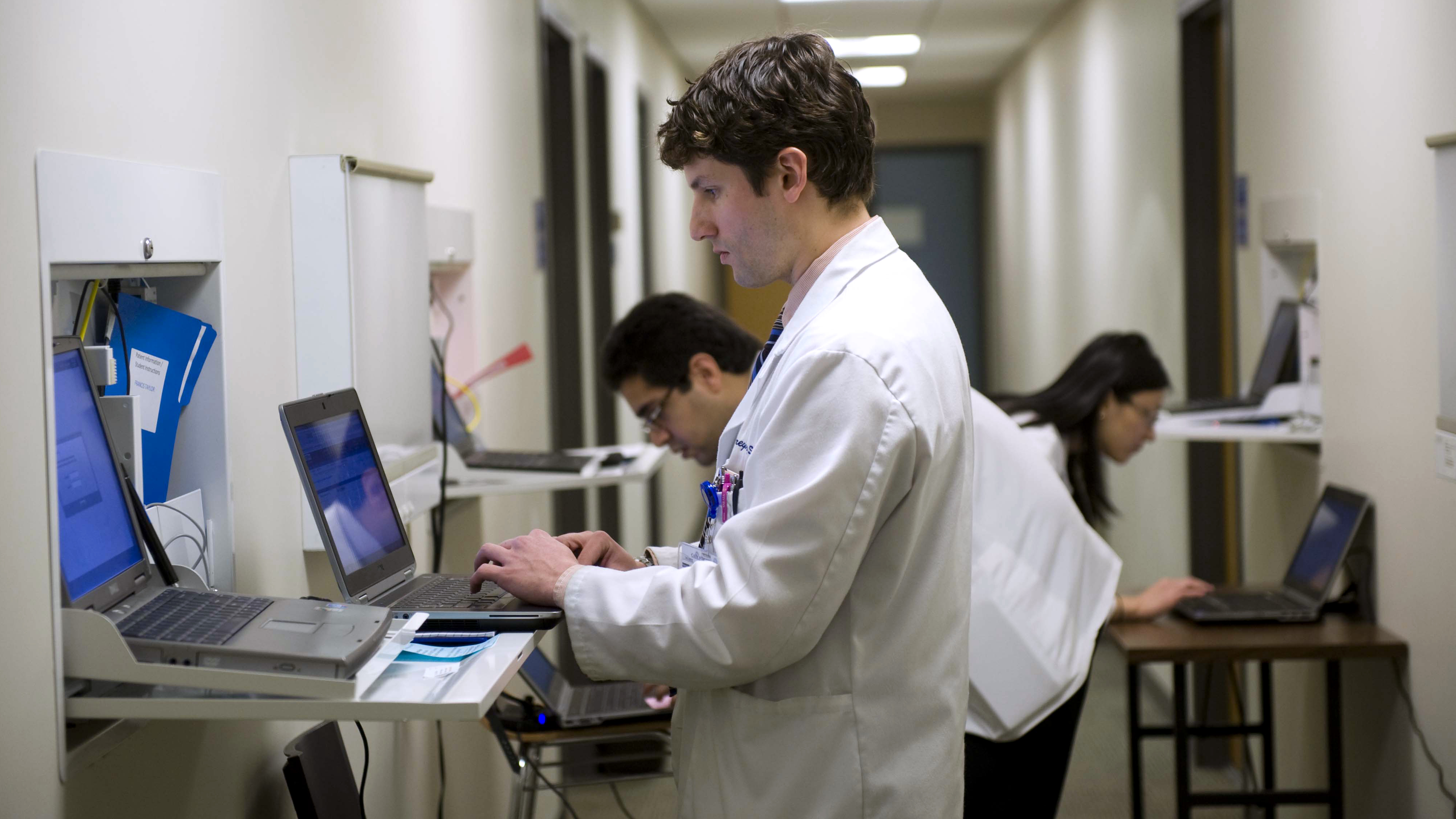 Students at Georgetown University School of Medicine  prepare to meet with an actor playing a patient in an exam room in March.