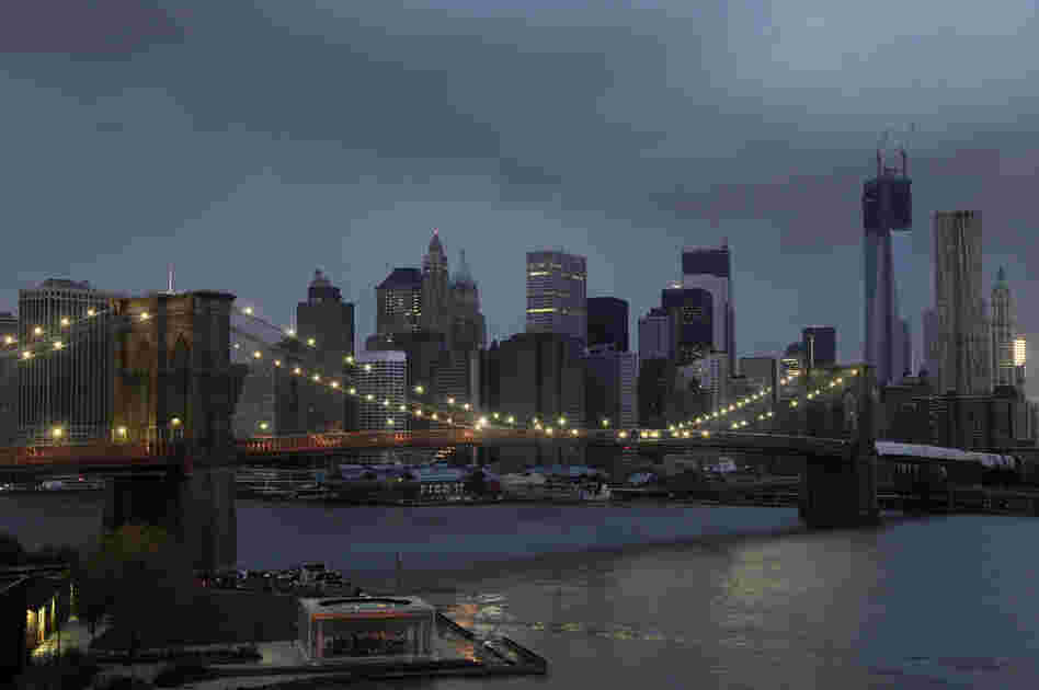 The lights on the Brooklyn Bridge stand in contrast to the lower Manhattan skyline which has lost its electrical supply following Superstorm Sandy on Tuesday.