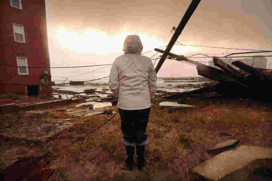 Kim Johnson inspects the area around her apartment building in Atlantic City, N.J. Johnson fled the area when the water began to rise Monday.