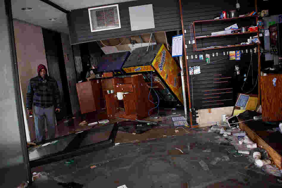 A man surveys a flooded store in the financial district of New York City.
