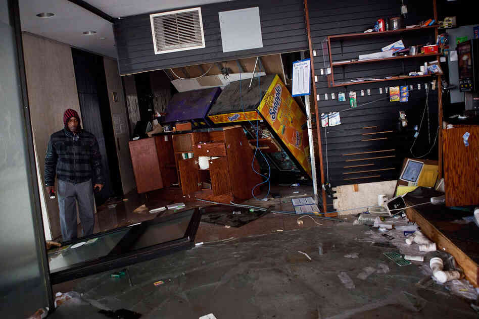 A man surveys a flooded store in the financial district of New York City.