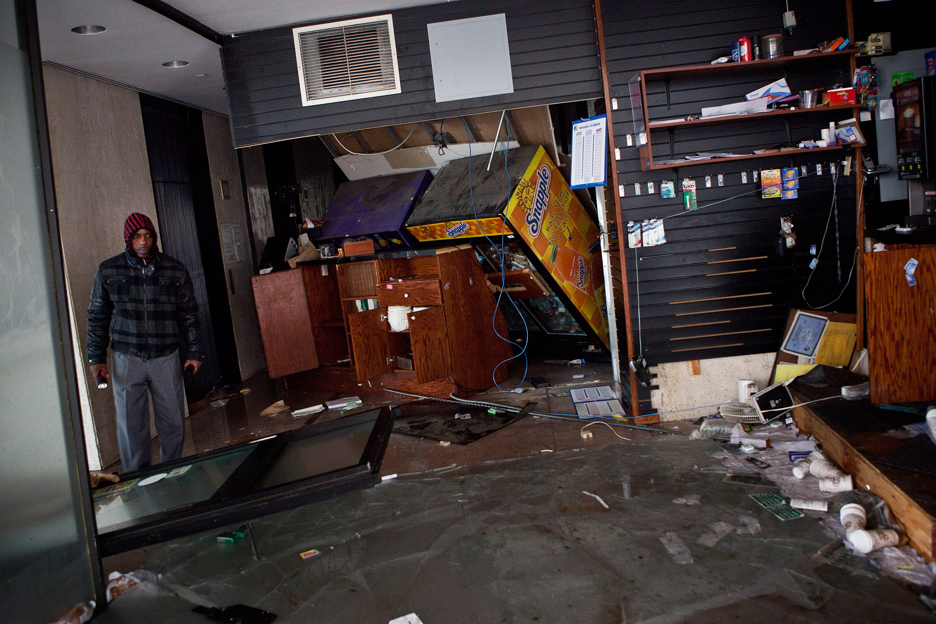 A man surveys a flooded store in the financial district of New York City.