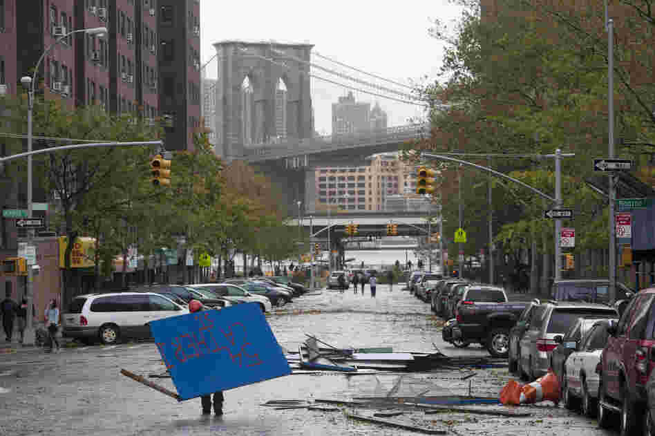 A worker picks up plywood from a scaffolding site in New York's Lower East Side in the aftermath of Sandy on Tuesday.