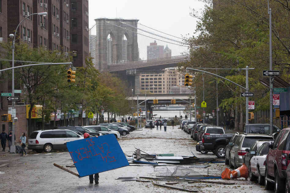 A worker picks up plywood from a scaffolding site in New York's Lower East Side in the aftermath of Sandy on Tuesday.