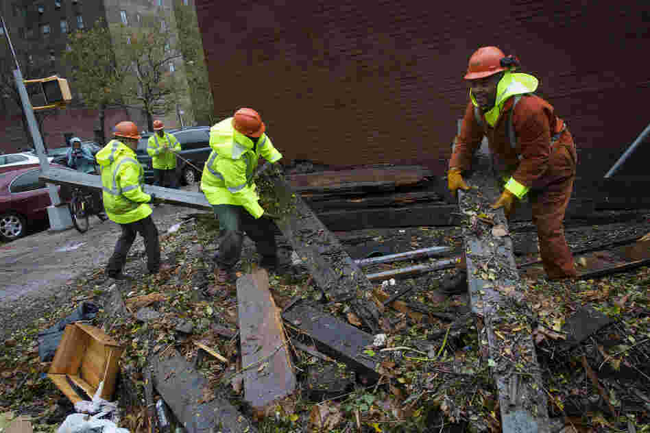 Workers clear debris outside the Consolidated Edison power sub-station on 14th Street on Tuesday, in New York City. 