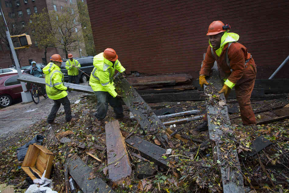 Workers clear debris outside the Consolidated Edison power sub-station on 14th Street on Tuesday, in New York City. 