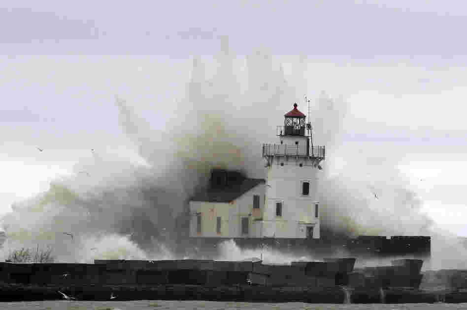 Waves pound a lighthouse on the shores of Lake Erie, near Cleveland. High winds spinning off the edge of Sandy took a vicious swipe at northeast Ohio, uprooting trees, cutting power to hundreds of thousands, forcing school closures and flooding parts of major commuter arteries that run along the lake.