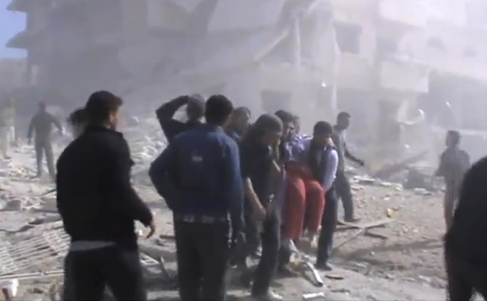 An image taken from video obtained from the Shaam News Network, authenticated by AP reporting, shows attempts to rescue the wounded in Idlib, northern Syria following heavy bombing from military warplanes.