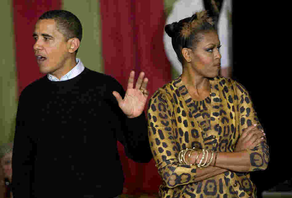President Obama is trying to justify his lack of costume and Michelle is NOT. HAVING. IT. This is what happens when you don't dress up. (The Obamas greet trick-or-treaters at the White House in 2009.)