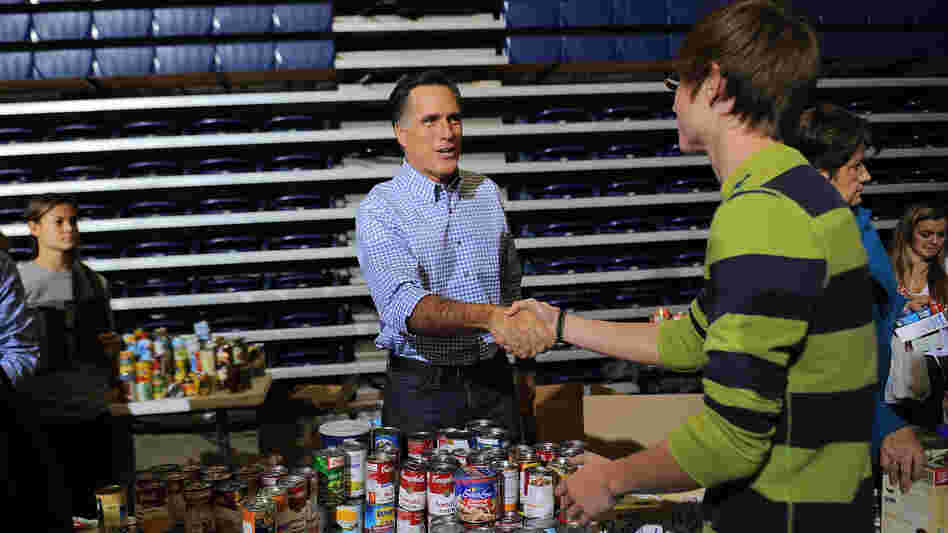 Mitt Romney helps collect and pack donated goods for those affected by Hurricane Sandy, in Kettering, Ohio, on Tuesday.