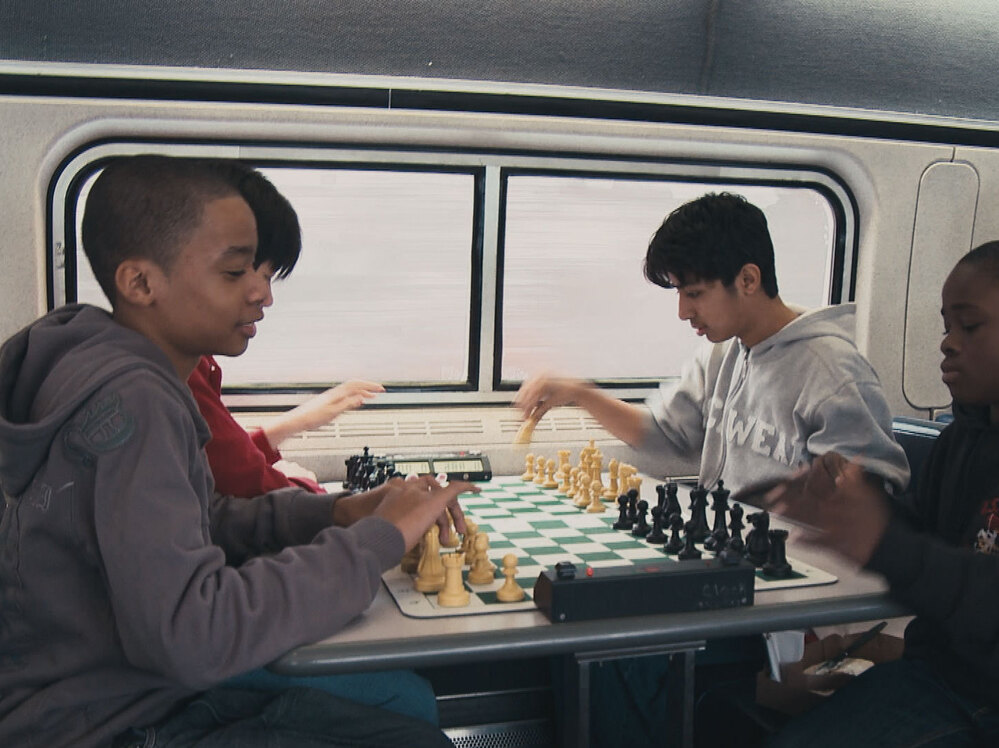These up-and-coming Bobby Fischers are always sharpening their game. Instead or napping of texting, they practice on the train.
