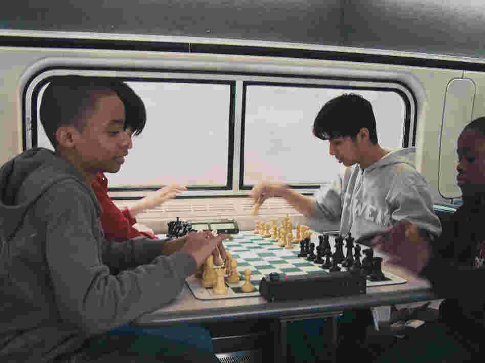 These up-and-coming Bobby Fischers are always sharpening their game. Instead or napping of texting, they practice on the train.