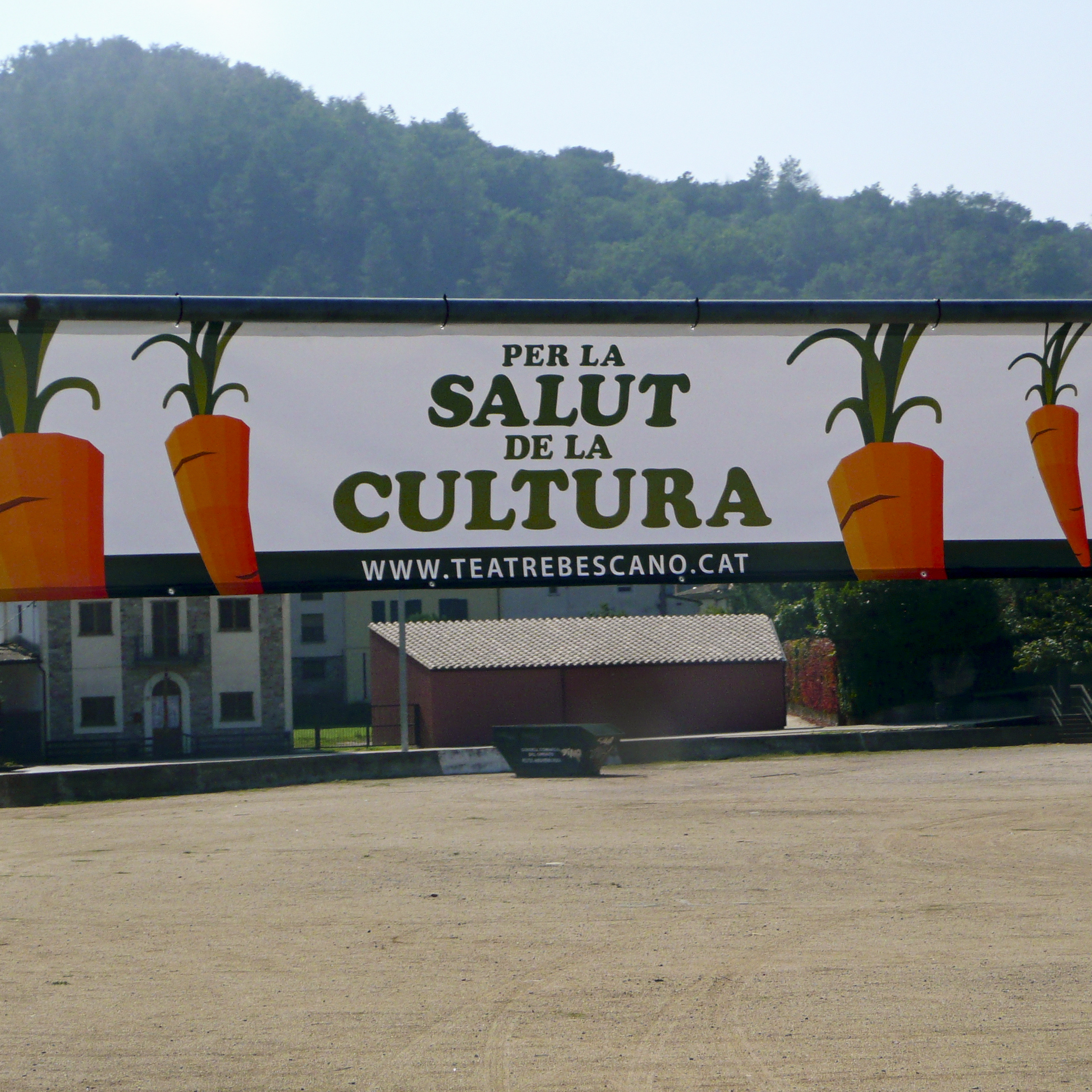 Banners at the entrance to the village of Bescan&oacute; announce the local theater's carrot-selling campaign, with the slogan "For the Health of Culture," in Catalan language.