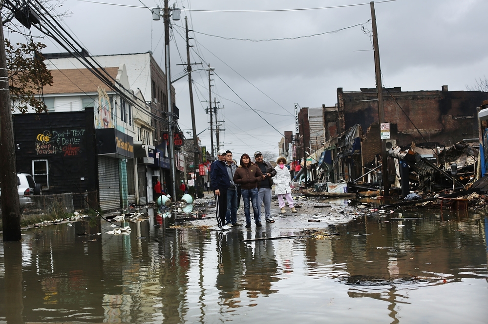 People look at homes and businesses destroyed during Superstorm Sandy on Tuesday in the Rockaway section of Queens, N.Y.