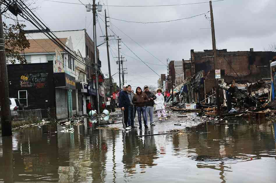People look at homes and businesses destroyed during Superstorm Sandy on Tuesday in the Rockaway section of Queens, N.Y.