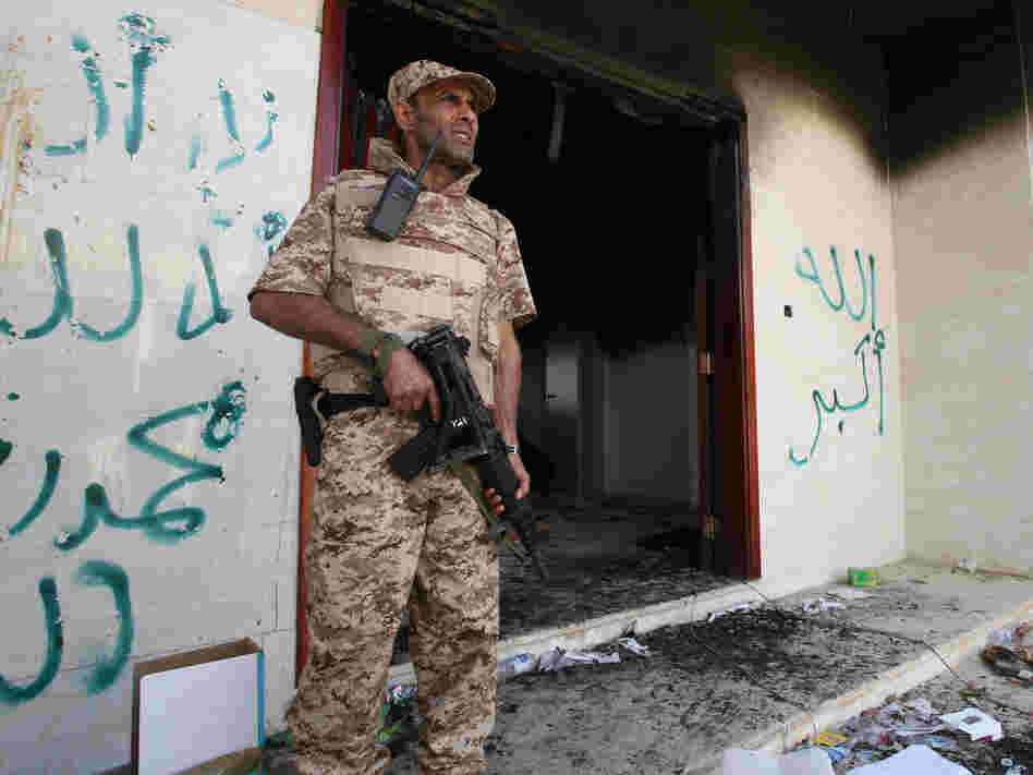 A Libyan military guard stands in front of one of the U.S. Consulate's burned out buildings on Sept. 14. The U.S. is offering new details of the attack on the consulate that killed four Americans, including Ambassador Chris Stevens.