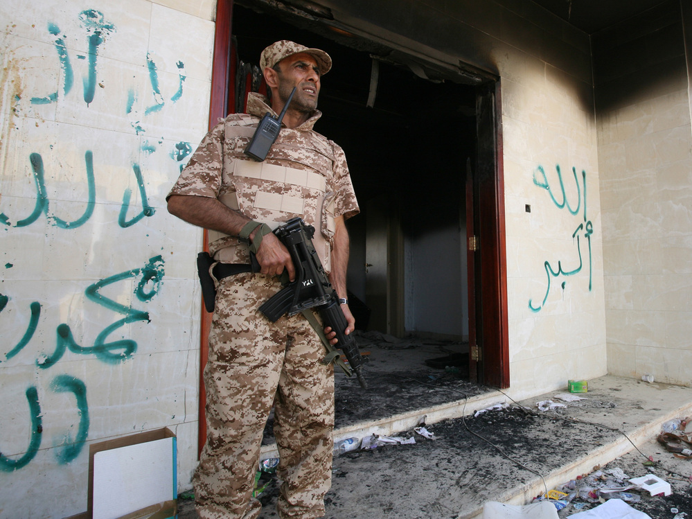 A Libyan military guard stands in front of one of the U.S. Consulate's burnt out buildings on Sept. 14. The U.S. is offering new details of the attack on the consulate that killed four Americans, including Ambassador Chris Stevens.