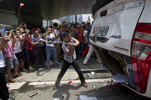 As part of a demonstration against Japan, a Chinese protester destroys a Japanese-model police car in Shenzhen in southern China on Aug. 19.