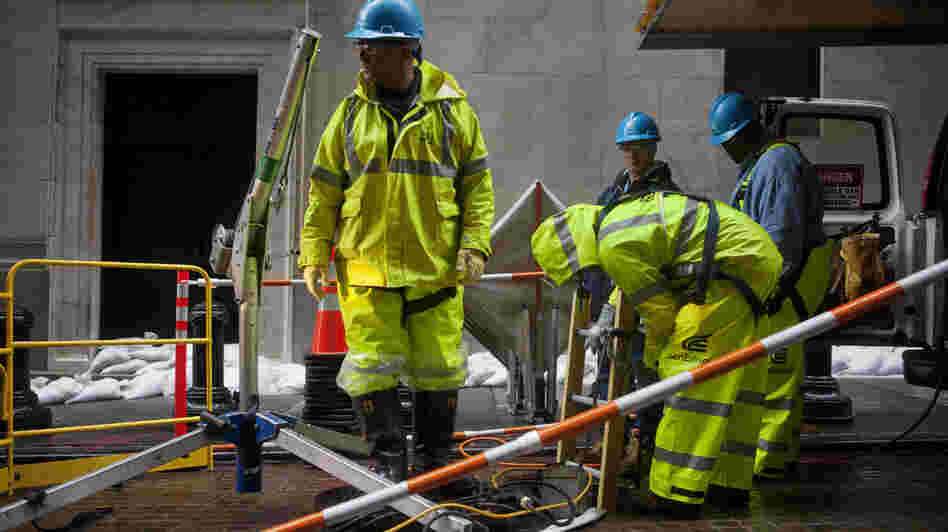 Consolidated Edison workers try to repair damage near the New York Stock Exchange on Tuesday. Consolidated Edison workers try to repair damage near the New York Stock Exchange on Tuesday.