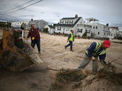Workers clean up debris left by Superstorm Sandy in Long Beach Island, N.J., on Wednesday. The storm may lead to layoffs as business losses mount, but also could result in hiring related to rebuilding. Workers clean up debris left by Superstorm Sandy in Long Beach Island, N.J., on Wednesday. The storm may lead to layoffs as business losses mount, but also could result in hiring related to rebuilding.