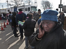 Evangean Pugh, far right, talks on a phone as she waits in line to apply for recovery assistance at a FEMA processing center in Coney Island, in the Brooklyn borough of New York.