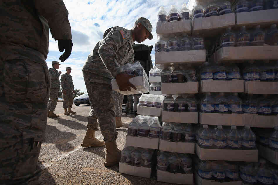 New York National Guard troops unload water to distribute to residents.