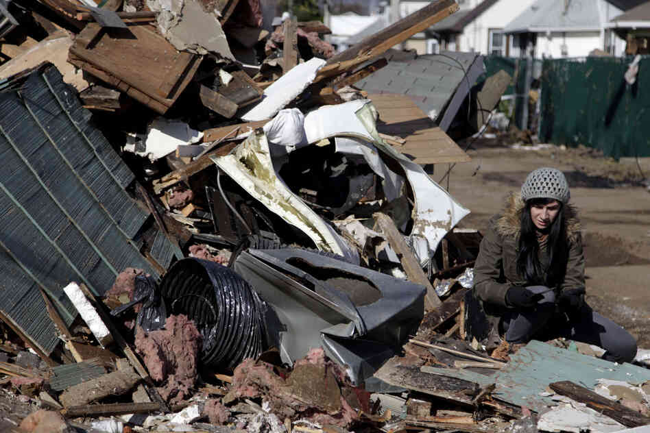 Julie Traina tries to recover some personal items from her parents' destroyed home.