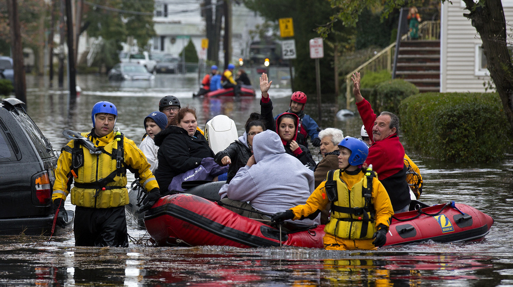 First responders rescue flood-stranded people from a sodden neighborhood in Little Ferry, N.J., on Tuesday.
